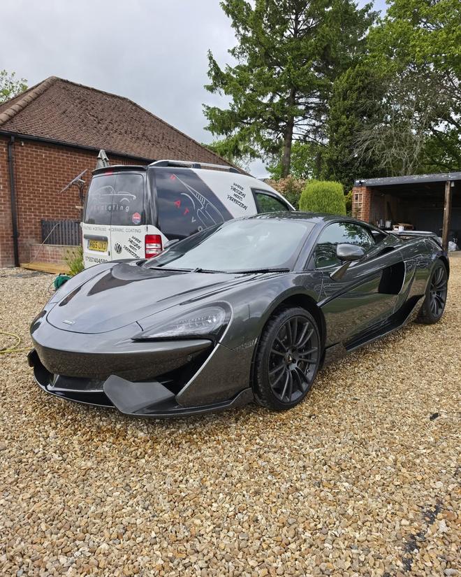 A freshly detailed McLaren 570S on a gravel driveway