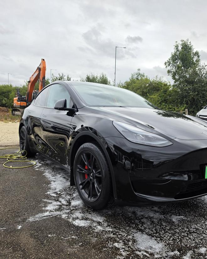 Close-up of a Tesla Model Y alloy wheel and red brake caliper after detailing