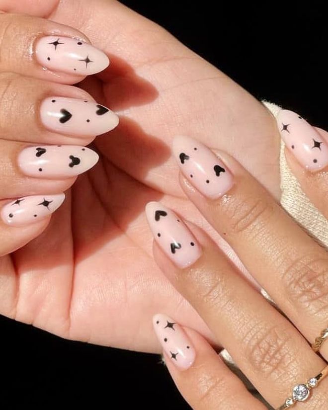 Sheer nude nails with tiny hand-painted stars and hearts